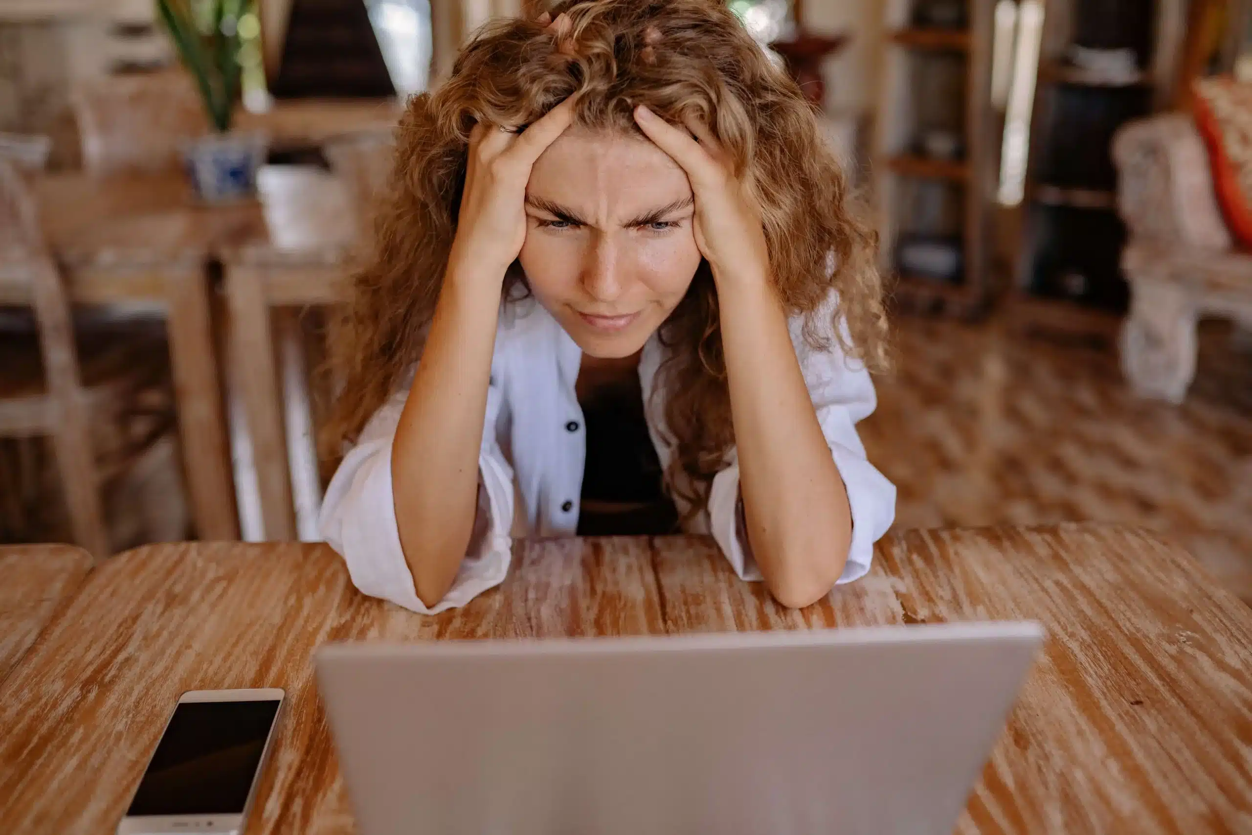 Frustrated woman looking at her laptop